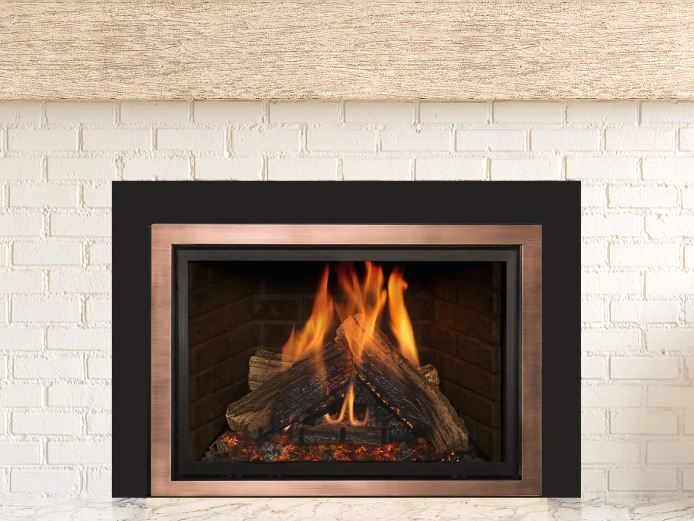 A Kozy Heat Nordik gas insert with a bronze frame in whitewashed brick
