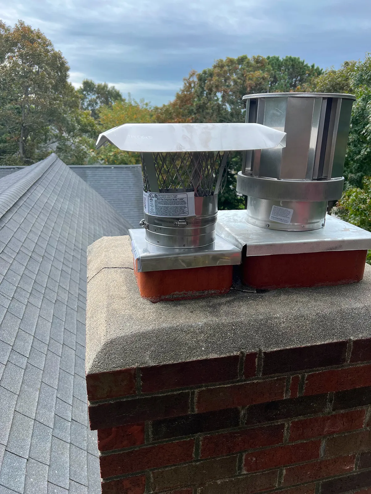 New stainless chimney caps on a brick chimney