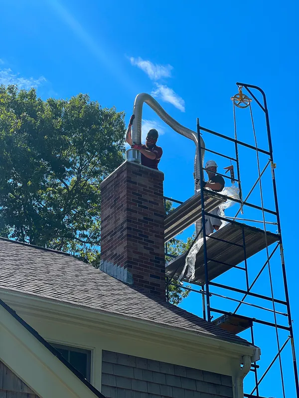A brick chimney being relined from scaffolding