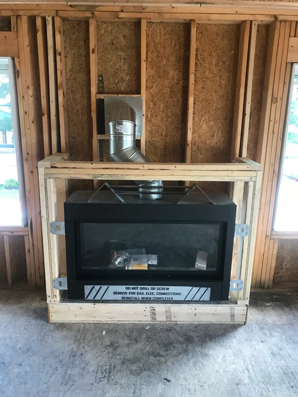A fireplace unit set in rough framing before finish work