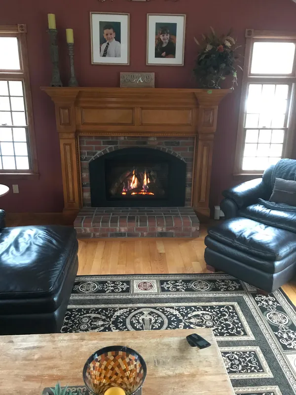 A gas insert burning beneath an oak mantel
