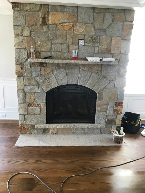 A stone fireplace surround during installation